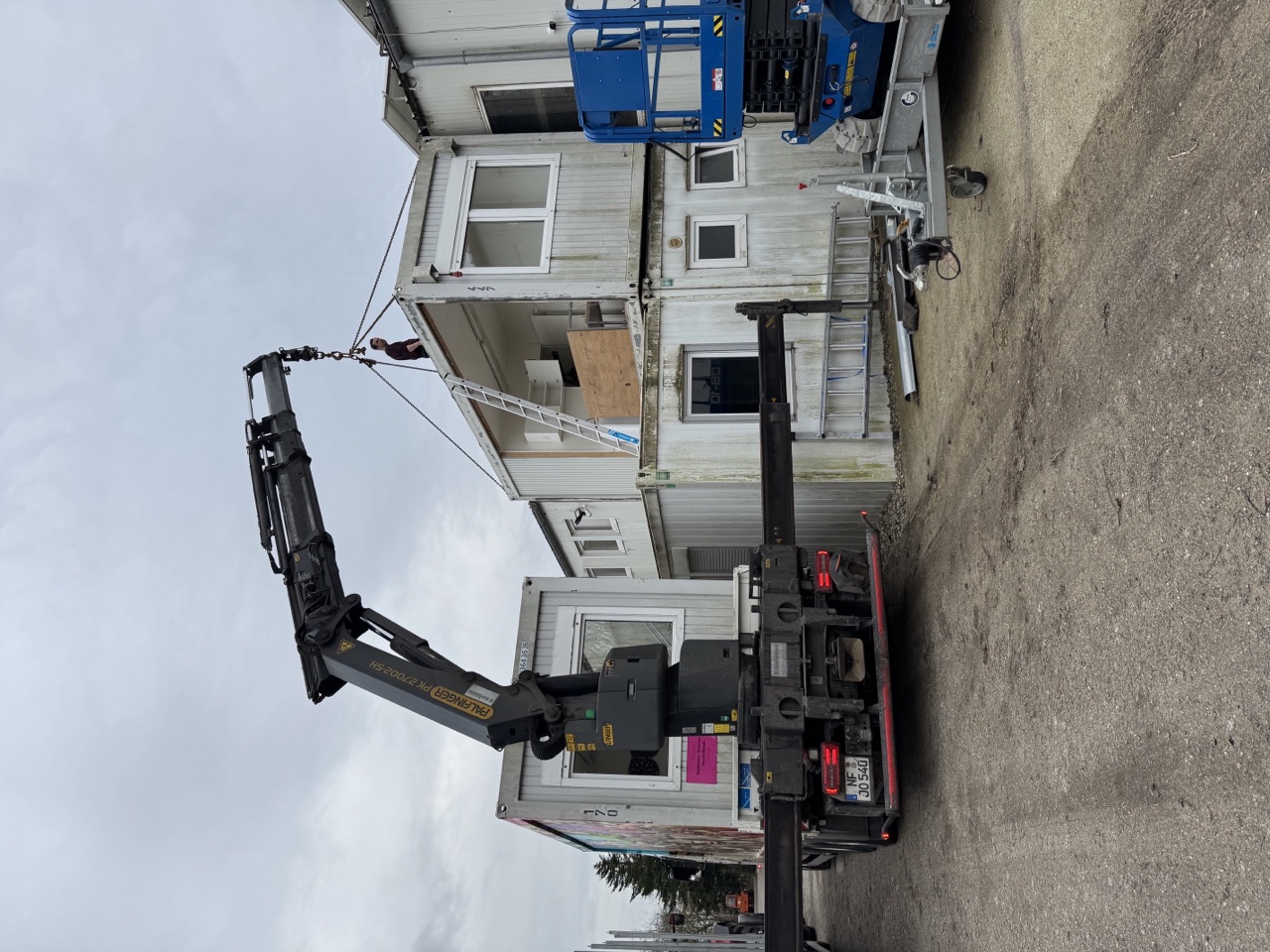Kranwagen von Johs. Oldenburg hebt mit dem Ladekran einen Container.